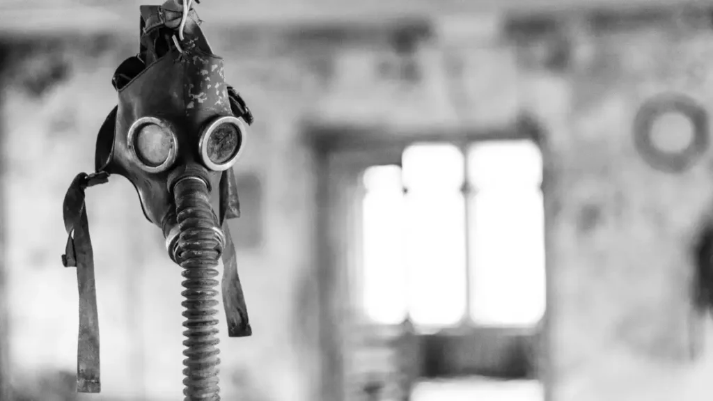 Old gas mask hanging in a decayed, abandoned room, symbolizing survival, danger, and the hidden cost of silence.