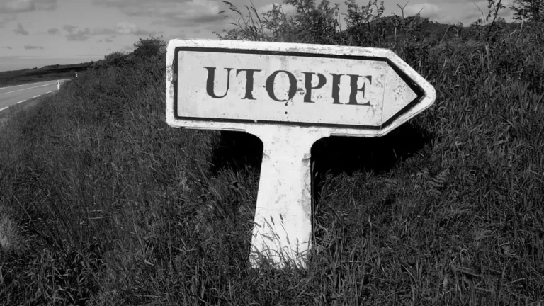 Weathered road sign reading “UTOPIE,” pointing toward an overgrown path.