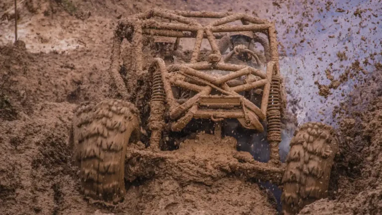Mud-covered off-road vehicle struggling through deep, waterlogged terrain