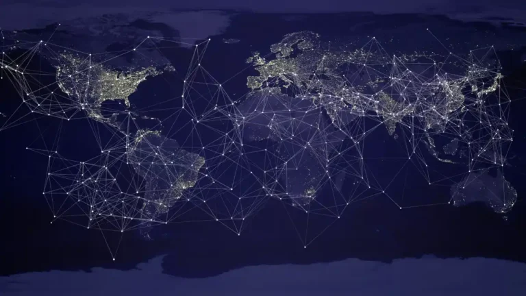 A world map at night showing illuminated cities connected by a glowing web of lines, symbolizing the global network of trade, communication, and power.