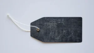 A blank dark label tag attached with a white string on a light background