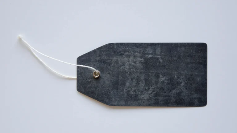 A blank dark label tag attached with a white string on a light background