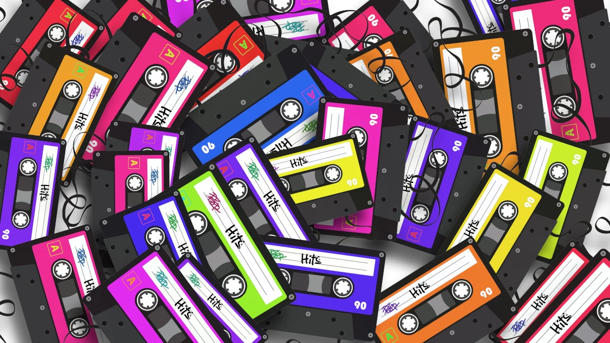 A chaotic pile of colorful cassette tapes scattered and overlapping, representing analog media and fragmented memory.